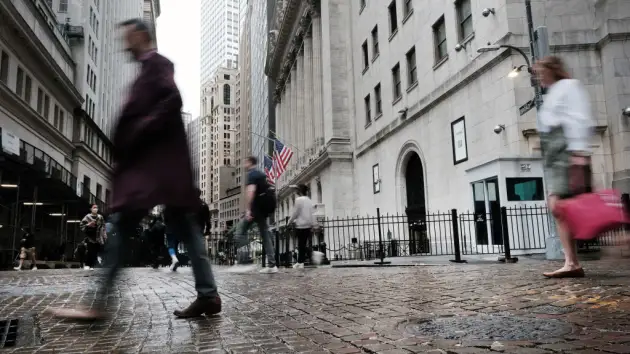 People walk by the New York Stock Exchange